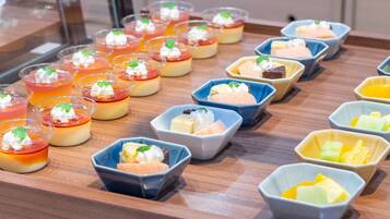 A dessert display with various colorful treats in small bowls and cups.