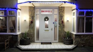 The Mossell Hotel entrance with a stone facade, a white door, and blue lights. - The Monsell Hotel (Skegness)