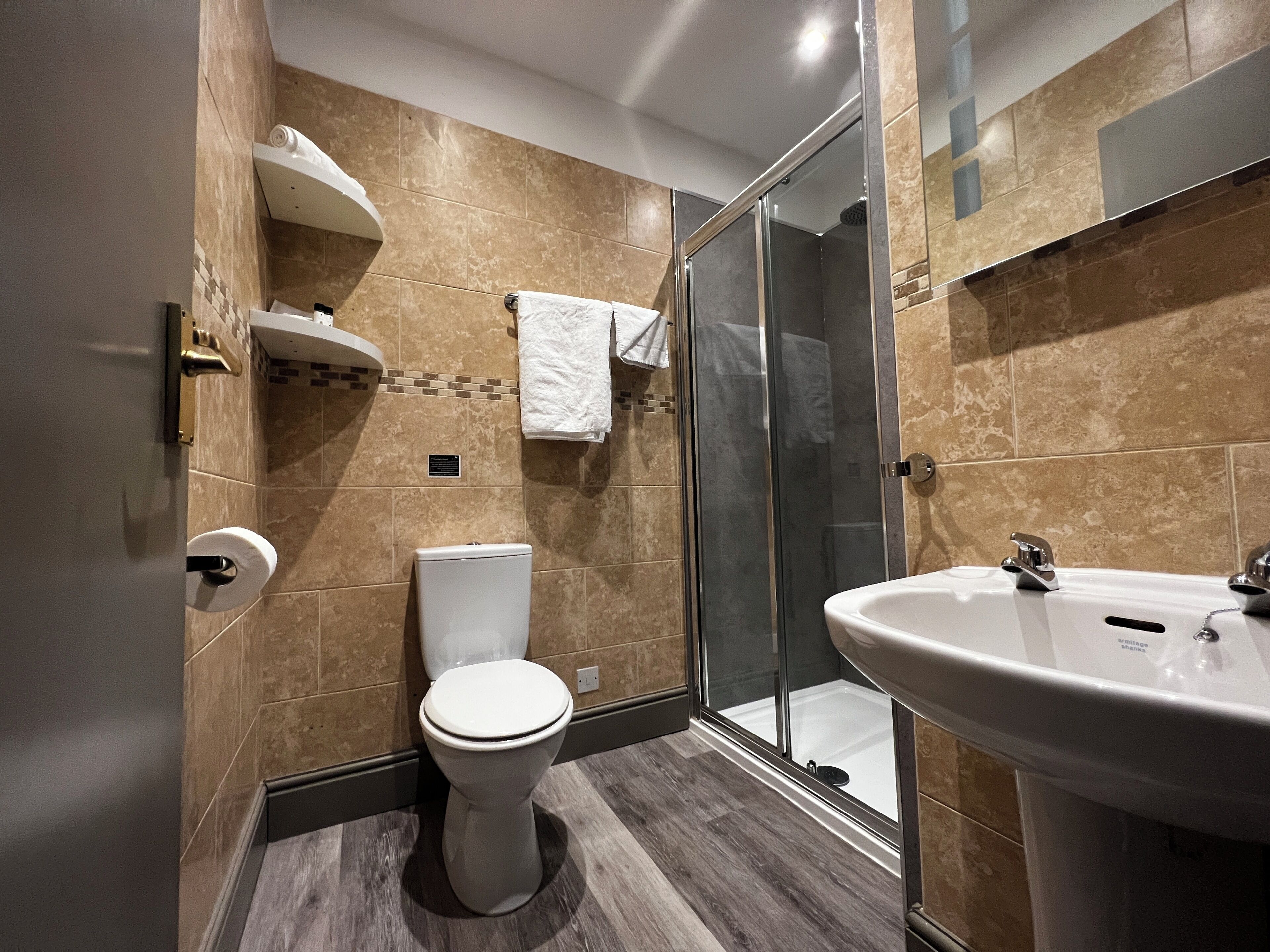 Un baño moderno con inodoro, ducha y lavamanos.