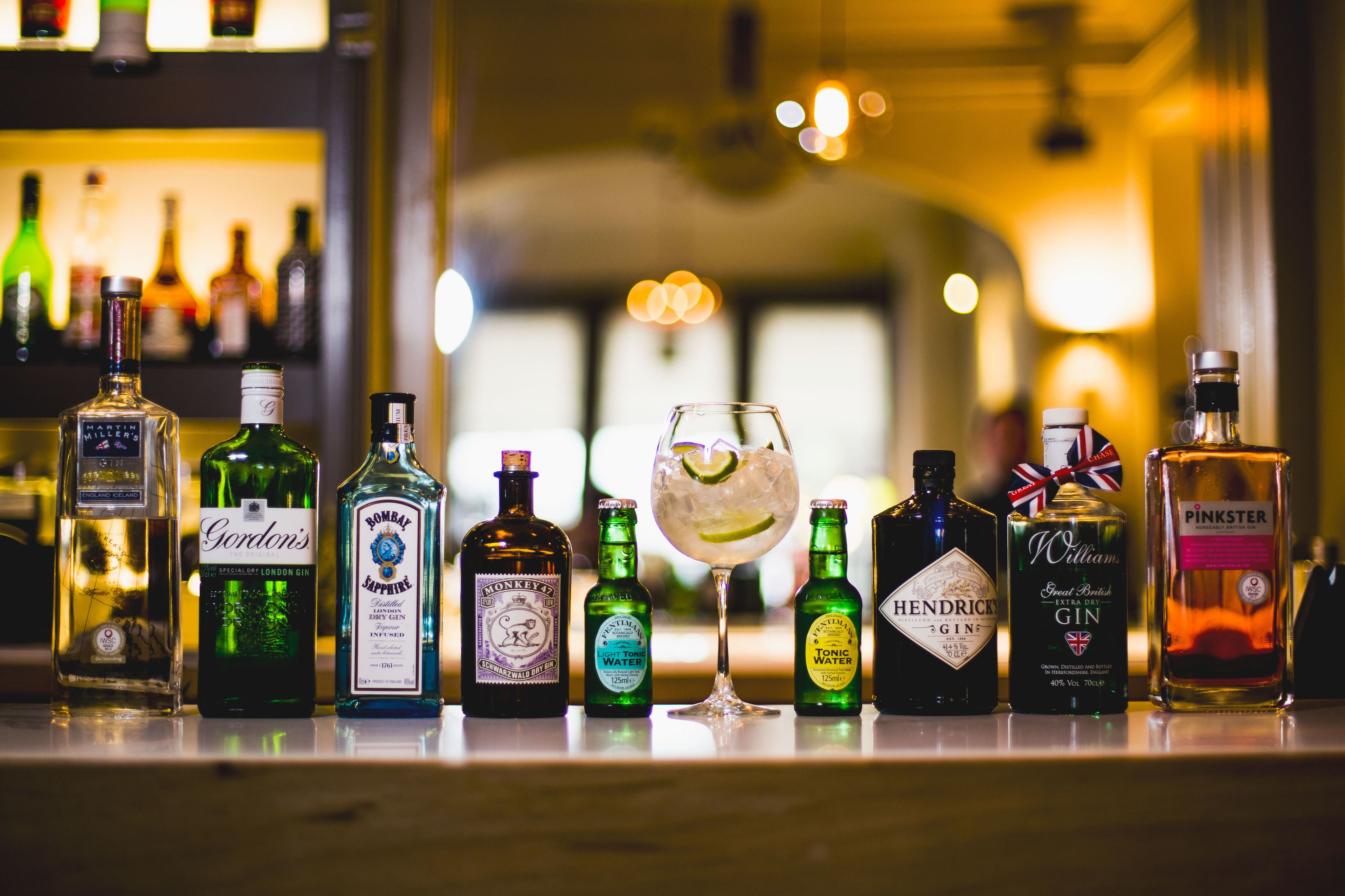 Eine Bartheke mit verschiedenen alkoholischen Getränken und einem Cocktailglas.
