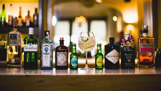 A bar counter with various bottles of alcohol and a glass of cocktail. - Herriots (Skipton)