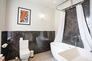Un baño moderno con inodoro, lavabo y bañera.