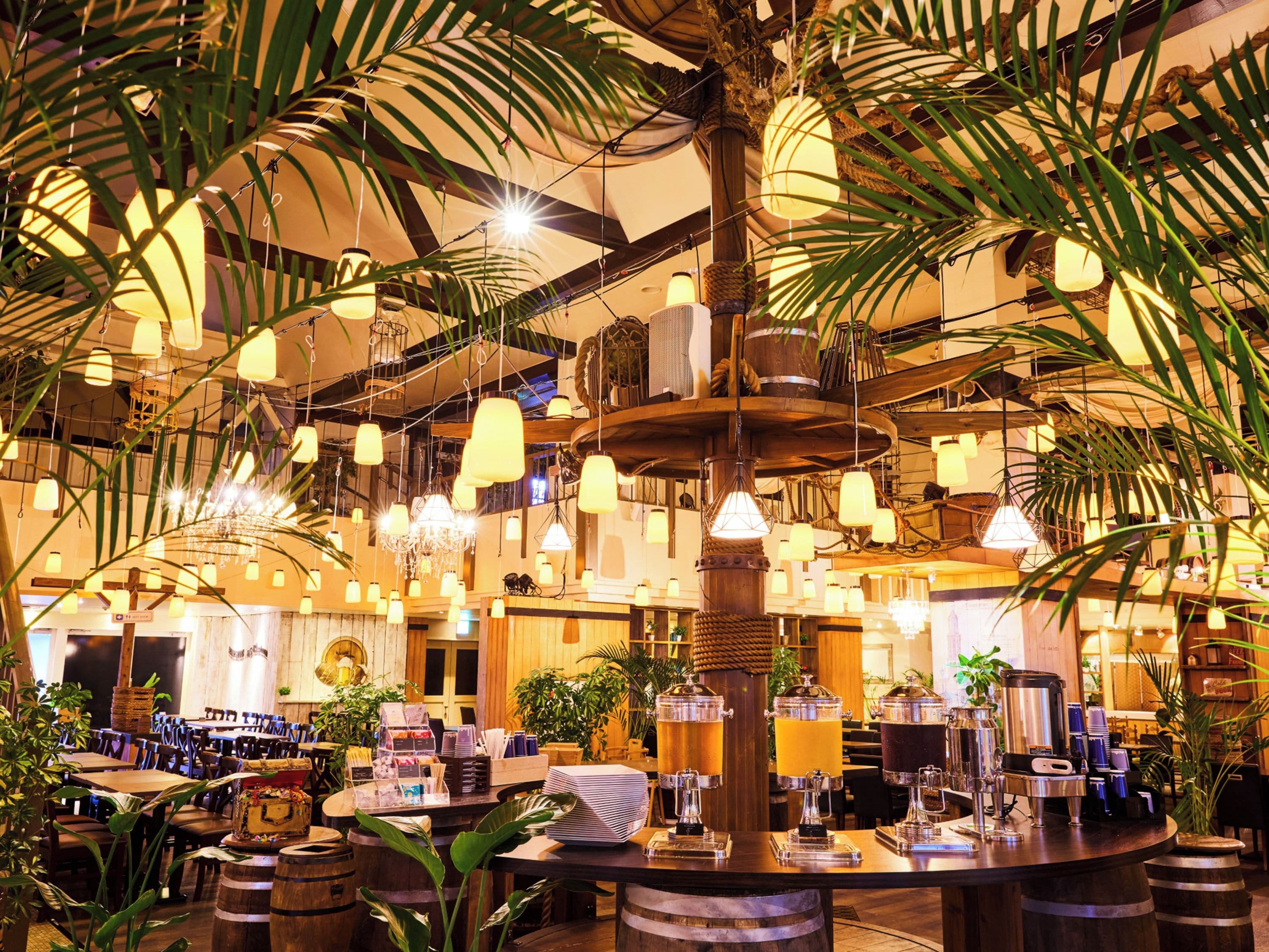 A restaurant with a central bar area, multiple hanging lights, and a variety of seating arrangements.