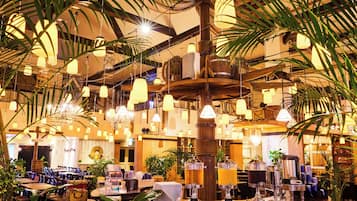 Un restaurante con barra central, múltiples lámparas colgantes y diferentes opciones de asientos.
