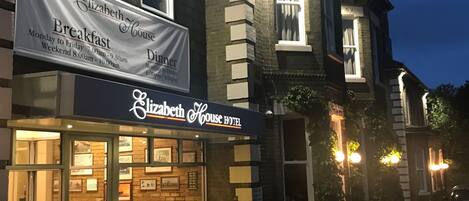 A building with a sign for Elizabeth House Hotel, indicating it offers breakfast and dinner services.
