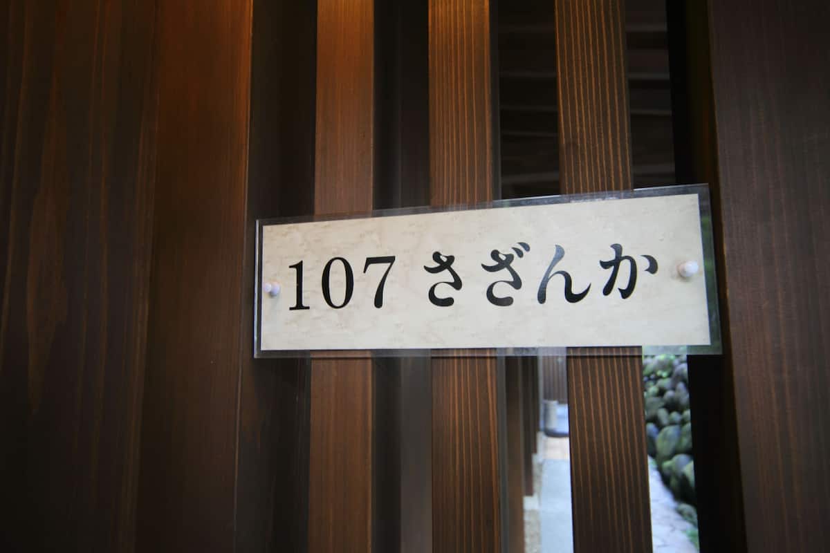 A sign with Japanese characters on a wooden background.