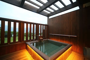 Un jacuzzi con barandas de madera y vistas a las montañas.