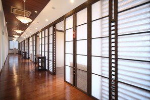 Un pasillo con suelo de madera, puertas correderas e iluminación en el techo.