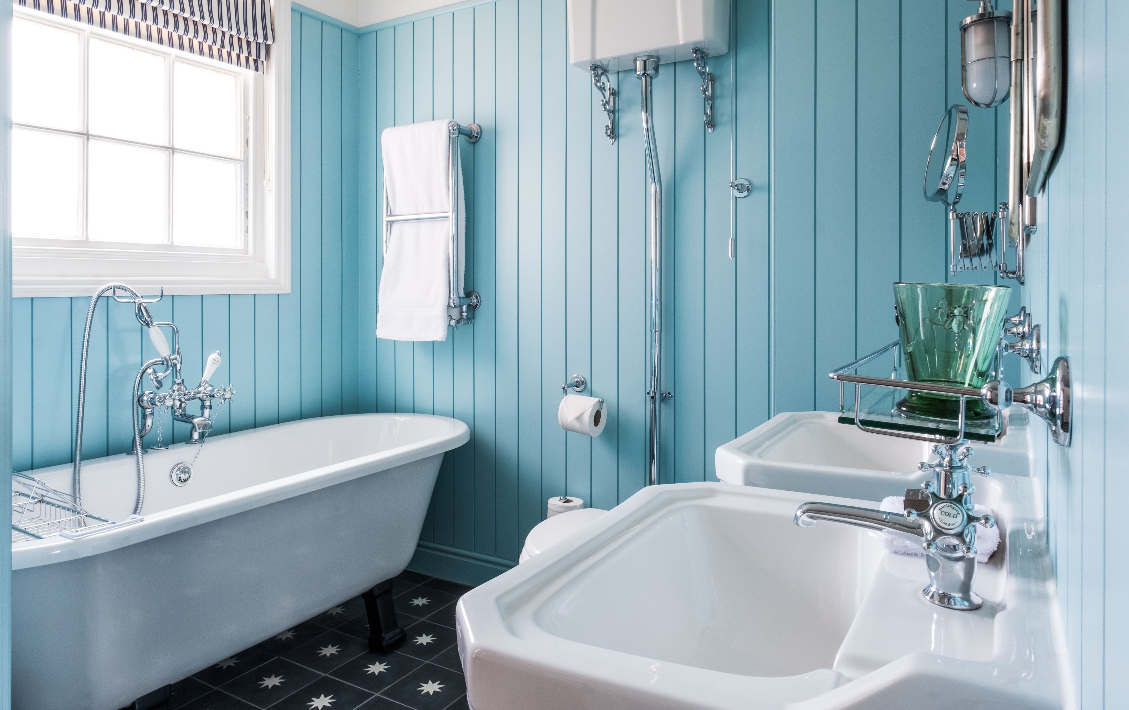 Une salle de bain avec une baignoire sur pieds, un lavabo et des toilettes.