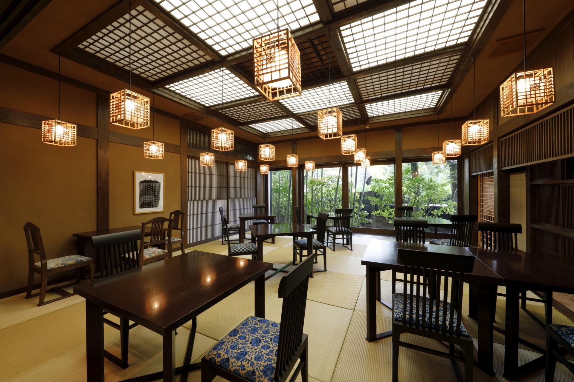 A traditional Japanese-style dining area with tatami mats, wooden furniture, and shoji screens.