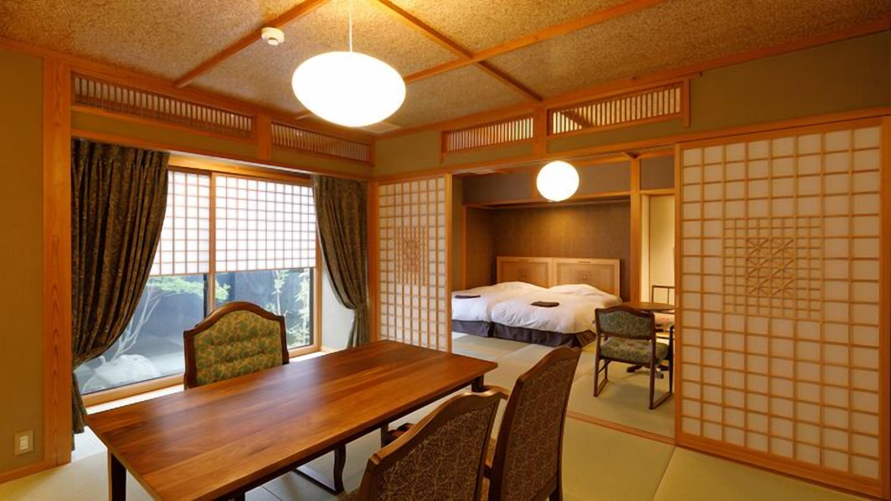 A traditional Japanese-style room with tatami flooring, a wooden table, a bed with white bedding, and sliding doors.
