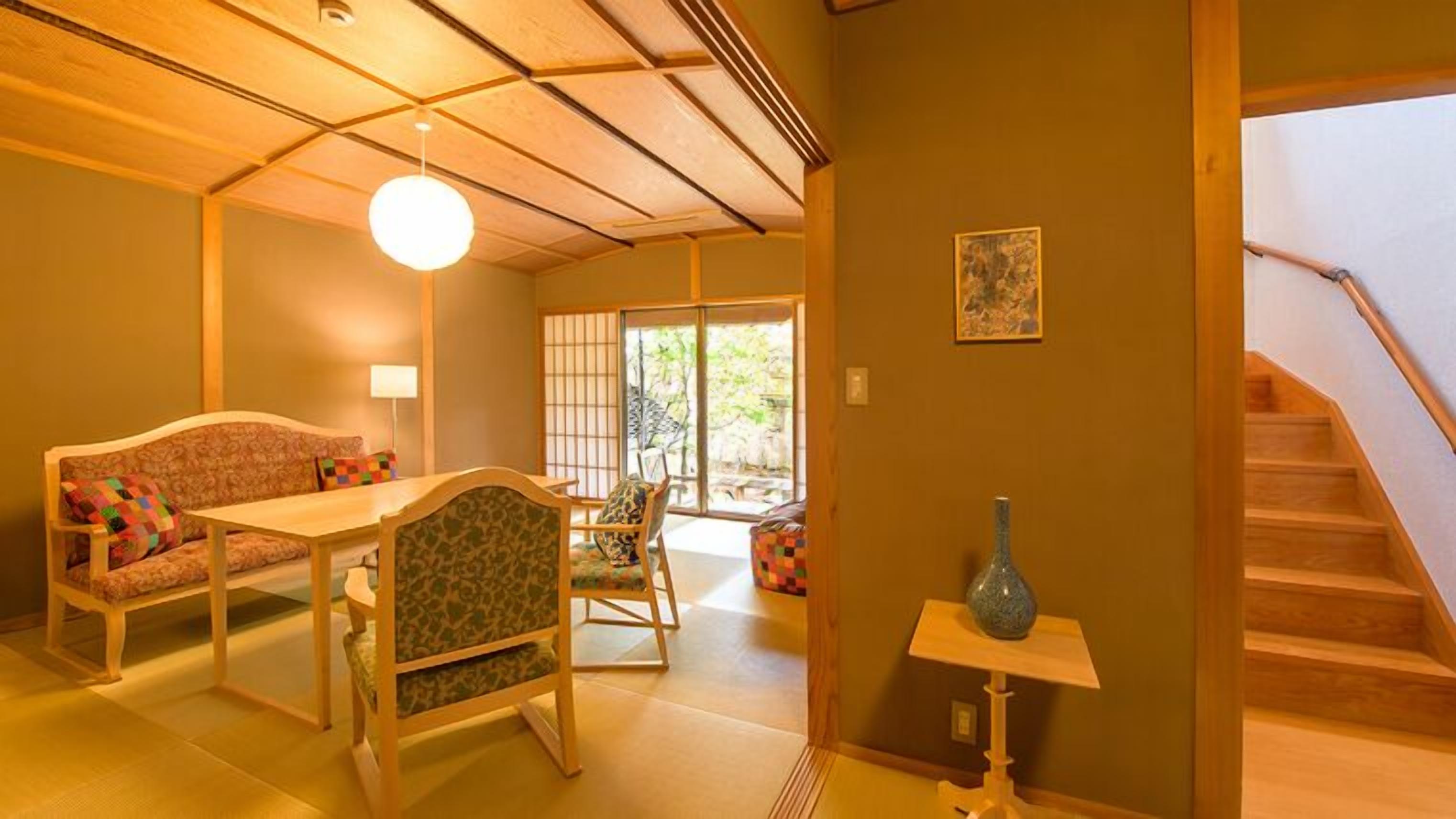 A traditional Japanese-style room with tatami flooring, a low table, and a sofa.
