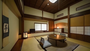 Ein traditioneller japanischer Raum mit Tatami-Böden, einem niedrigen Tisch und Schiebetüren.