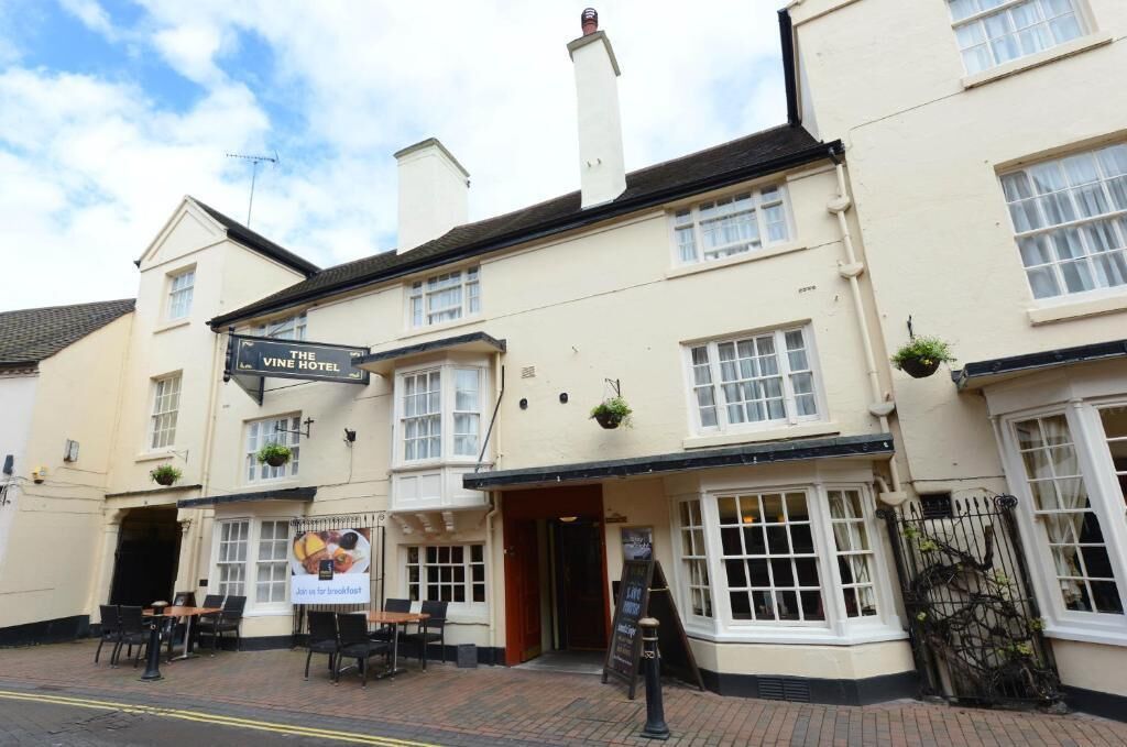 A traditional building with a sign reading 'The Vine Hotel.'