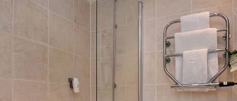A modern bathroom with a bathtub, toilet, and shower.