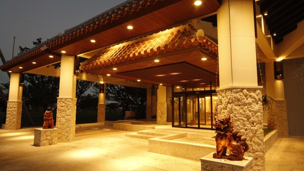 A building with a traditional tiled roof, stone pillars, and a statue of a horse. - Hotel Royal Marine Palace Ishigakijima (Ishigaki)
