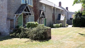 A traditional stone building with a green door and a small porch. - Bear Inn, Somerset by Marston's Inns (Street)