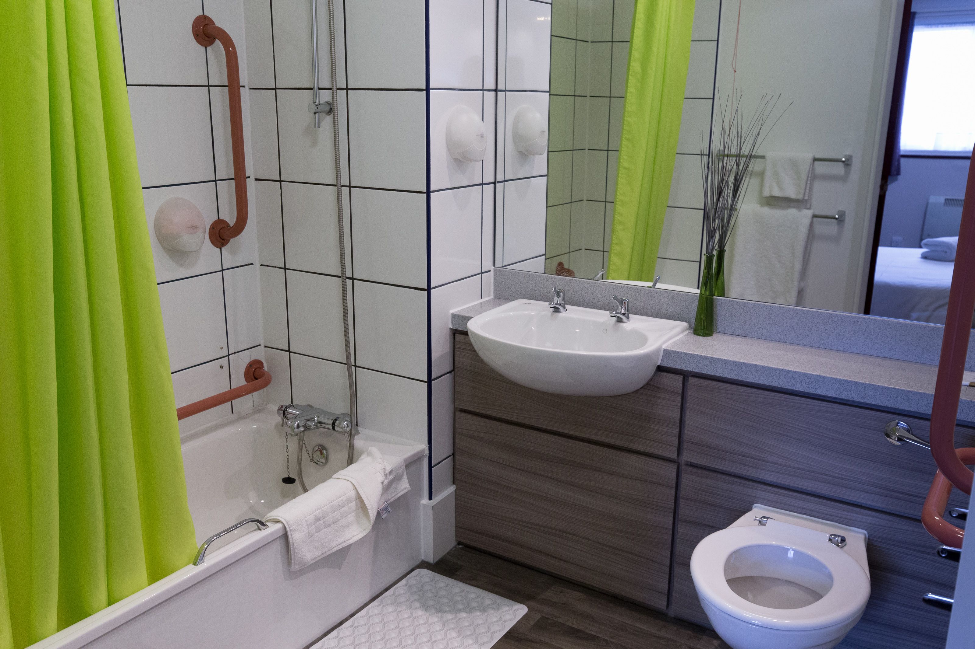 A modern bathroom with a bathtub, a sink, a toilet, and a shower.