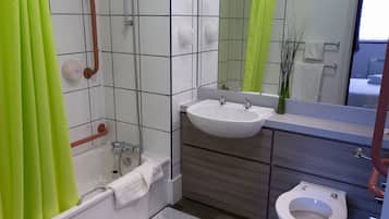 A modern bathroom with a bathtub, a sink, a toilet, and a shower.
