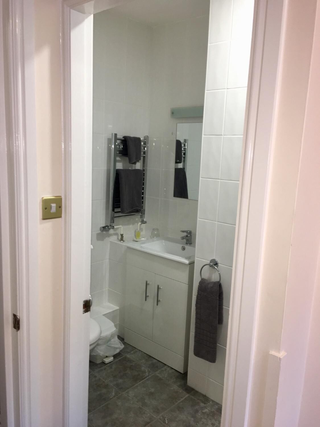 Un baño pequeño y limpio con inodoro, lavamanos y espejo.