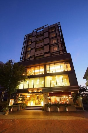 A modern hotel with a prominent entrance, large windows, and a well-lit facade.