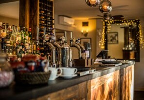 A bar area with multiple liquor bottles, a coffee machine, and a cash register. - The Peel Aldergate (Tamworth)