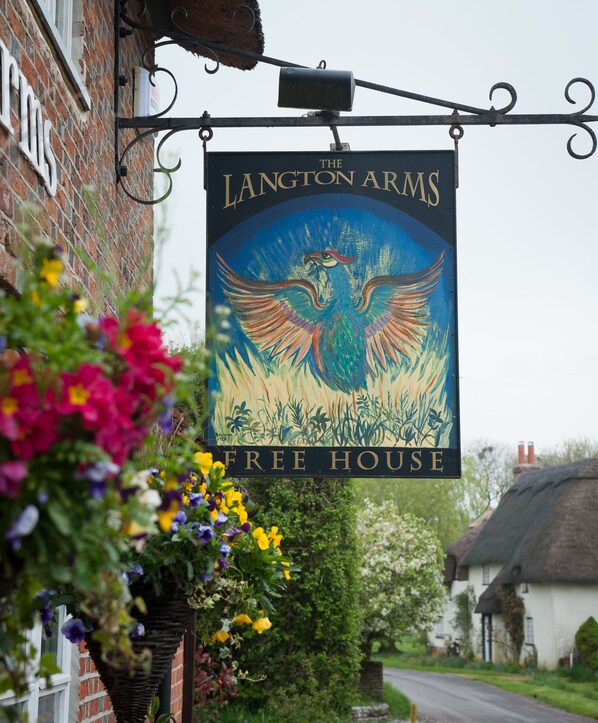 Señal del The Langton Arms Free House, con una ilustración de un pájaro.