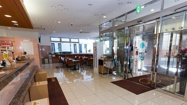 A hotel lobby with a reception desk, seating area, and a glass door entrance. - Toyoko Inn Aomori-eki Shomen-guchi (AOMORI)