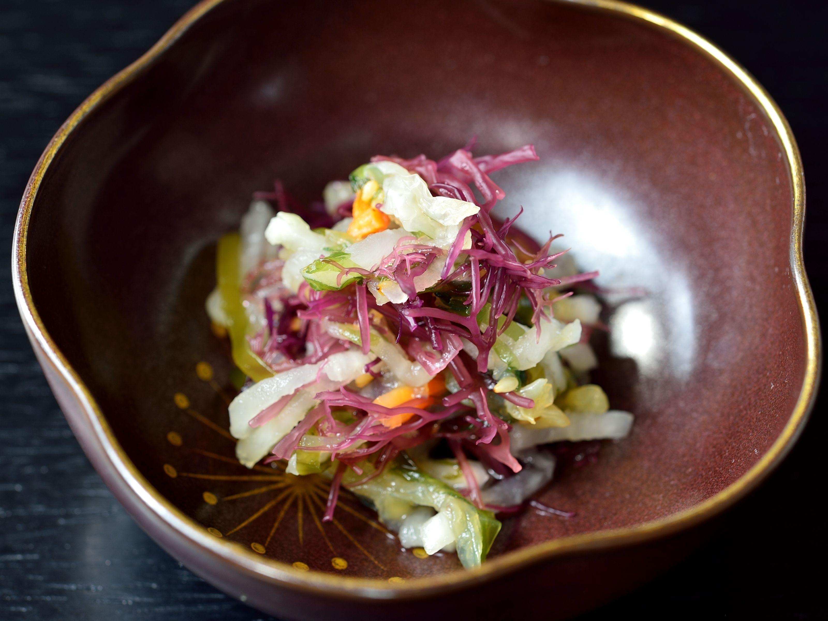 A bowl of colorful salad with various vegetables.