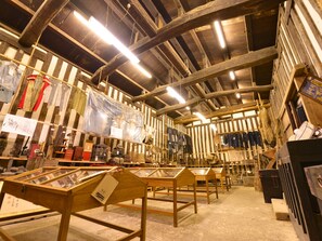 A warehouse-style room with wooden beams, metal shelving, and various items on display.