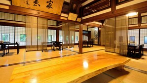 Una habitación japonesa tradicional con suelo de tatami, puertas correderas y una mesa de madera.