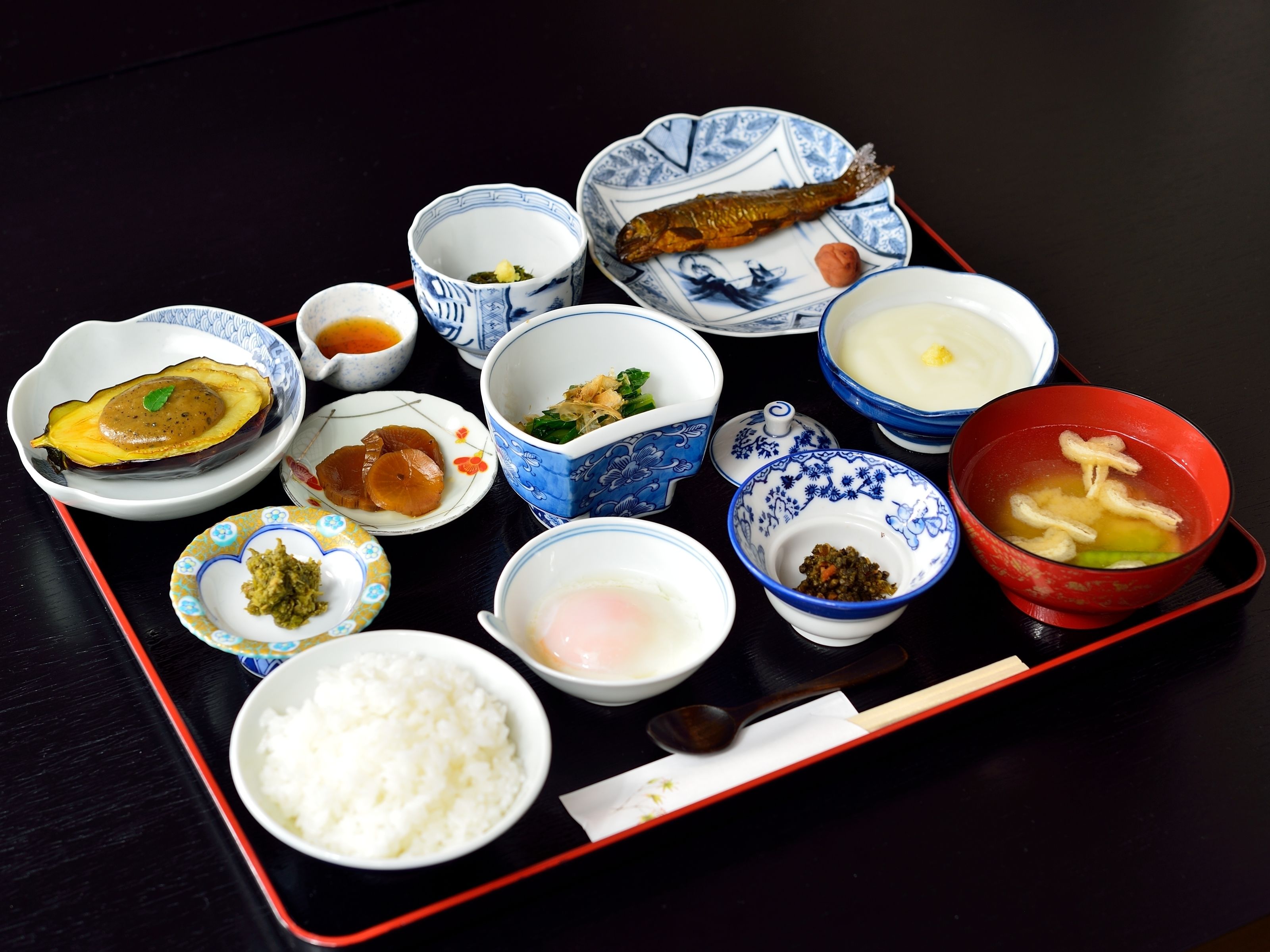 A variety of dishes on a tray, including rice, soup, and different types of food in bowls.