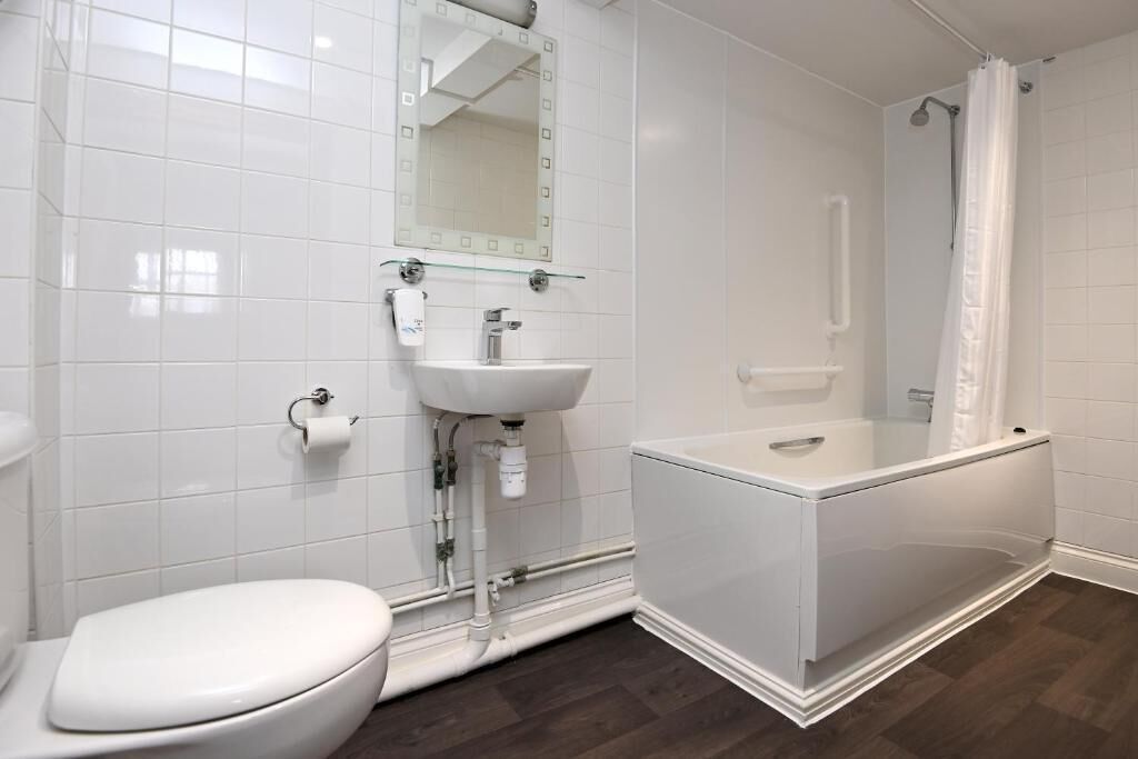 A modern bathroom with a toilet, sink, and bathtub.