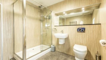 A modern bathroom with a glass-enclosed shower, a white sink, and a toilet.