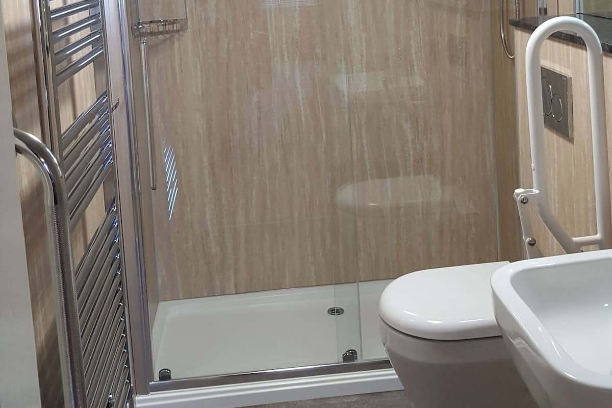 Un baño moderno con ducha, inodoro y lavamanos.