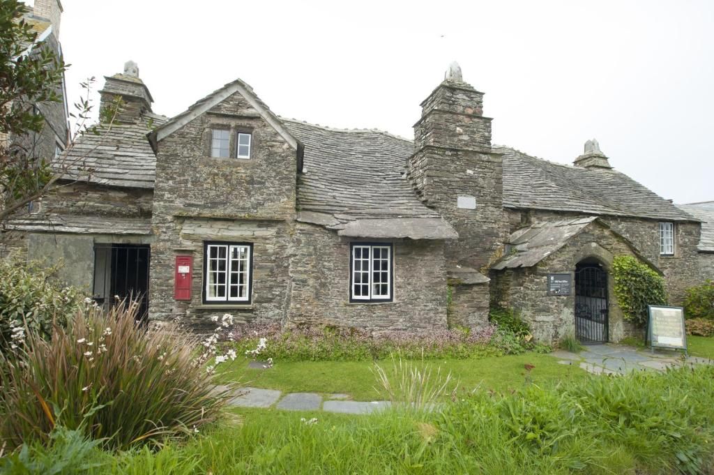 Un bâtiment en pierre à l’architecture traditionnelle, doté d’une entrée centrale, d’un petit porche et d’un jardin agrémenté d’un chemin de pierres.