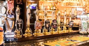 A bar counter with various beer taps and a Guinness tap. - King Arthur's Arms Inn (Tintagel)