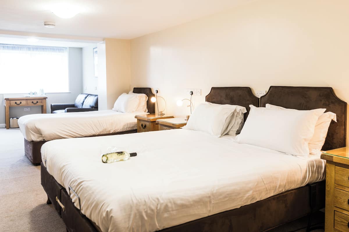 Habitación de hotel con dos camas, un escritorio y una silla.
