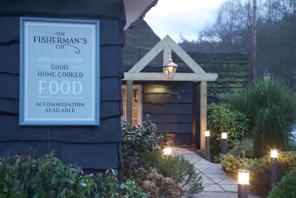 Un edificio con un letrero que anuncia 'The Fisherman's Cot', ofreciendo comida casera y alojamiento.