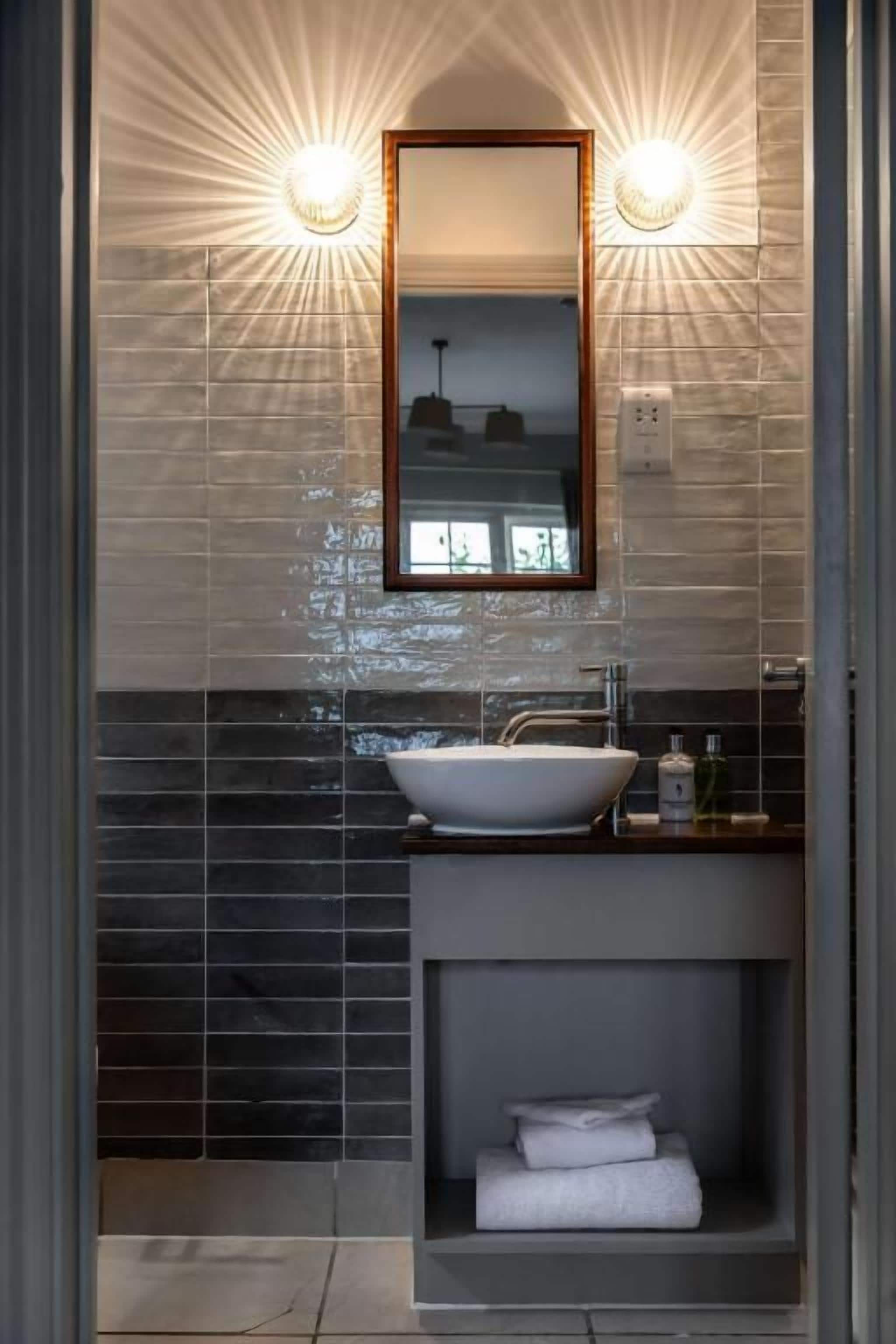 A bathroom with a vessel sink, a mirror, and a towel rack.