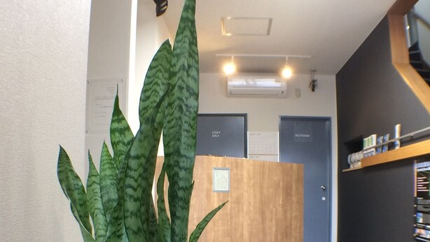 A reception area with a reception desk, a sign indicating 'Staff Only', and a 'Restroom' sign. - @ Business Hotel Ichinoseki (Ichinoseki)