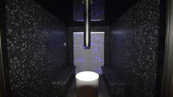 Stunning corridor with a central column, mosaic tile walls, and a grid ceiling.