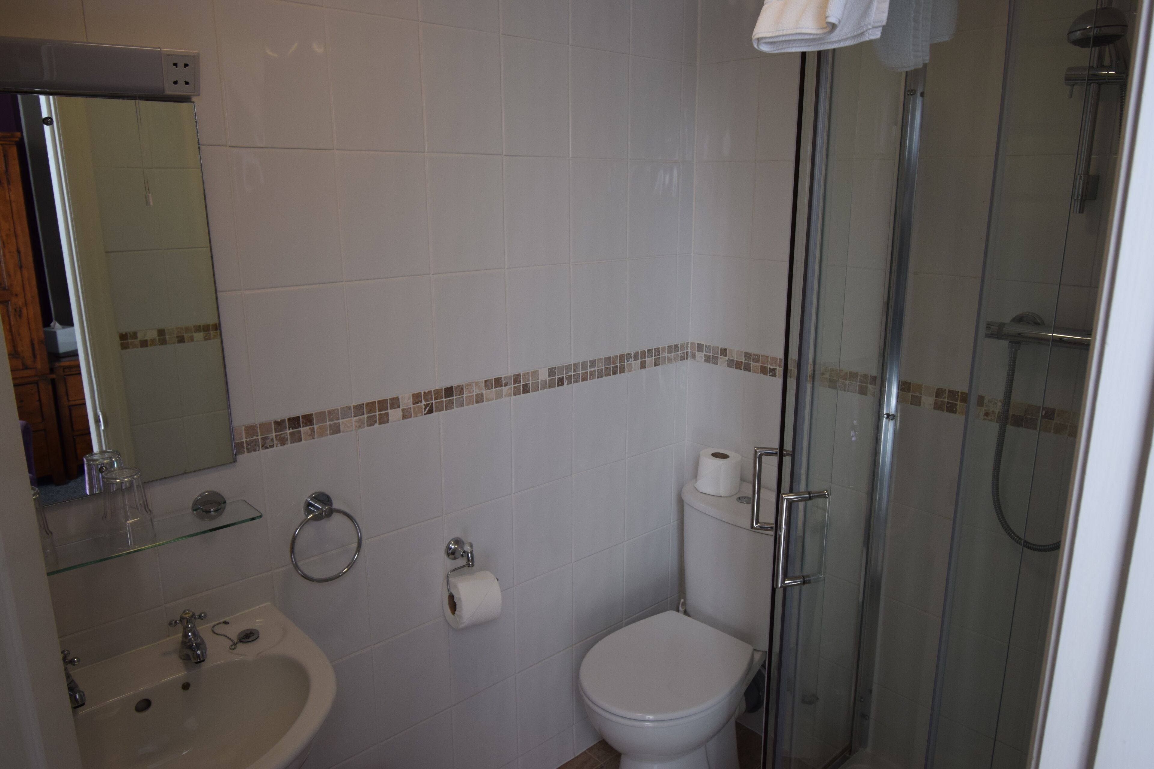 A bathroom with a sink, toilet, and glass-enclosed shower.