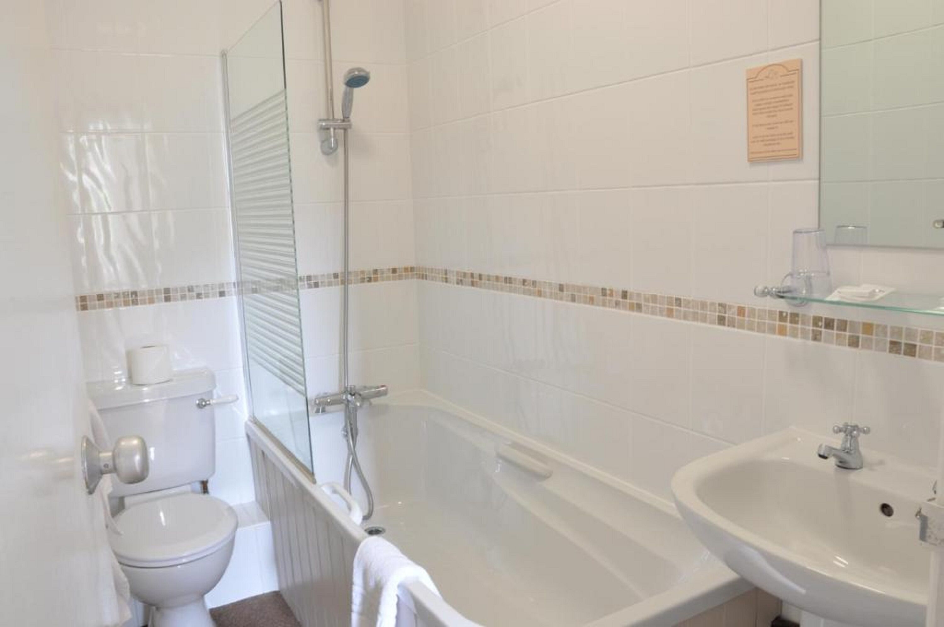 Une salle de bain comprenant des toilettes, une douche à parois de verre, une baignoire et un lavabo.