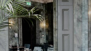 A restaurant with a rustic interior, featuring a large mirror, a ceiling fan, and blue patterned seating. - Lincombe Hall Hotel & Spa - Just for Adults (Torquay)