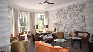 A spacious living room with a fireplace, comfortable seating, and a large window.