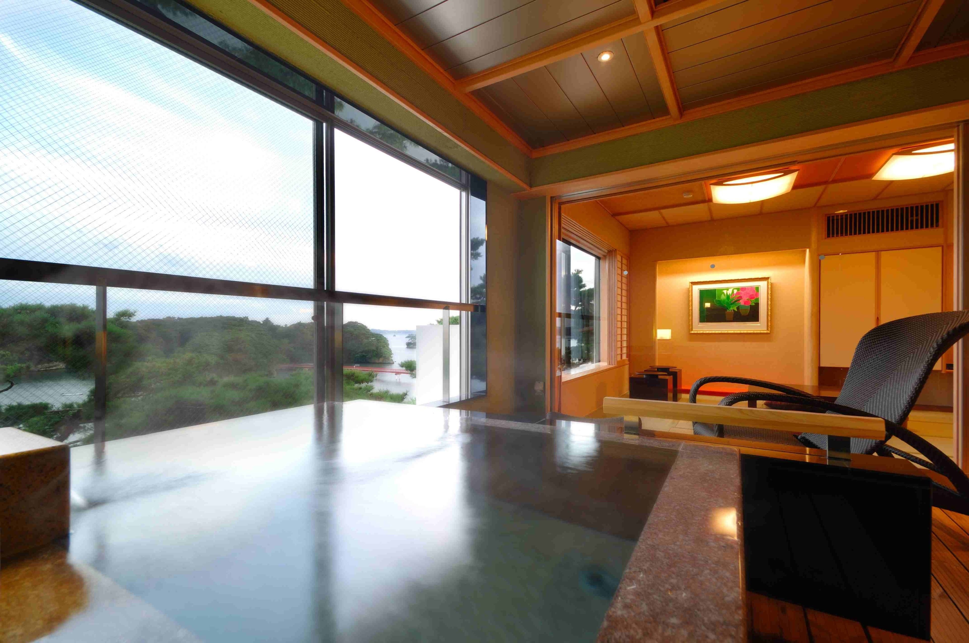 A modern interior with large windows, a wooden ceiling, and a seating area with a table.
