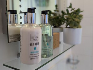 A display of Sea Kelp hand wash bottles on a glass shelf. - Villa Marina (Torquay)