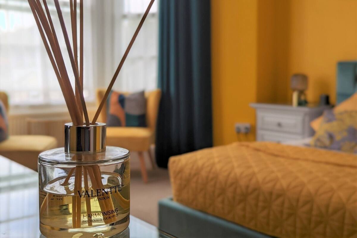 A bottle of Valente London harmonizing patchouli & eucalyptus in a clear glass bottle with reed diffusers.