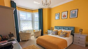 A bedroom with a bed, bedside tables, a desk, and a chair. - Villa Marina (Torquay)